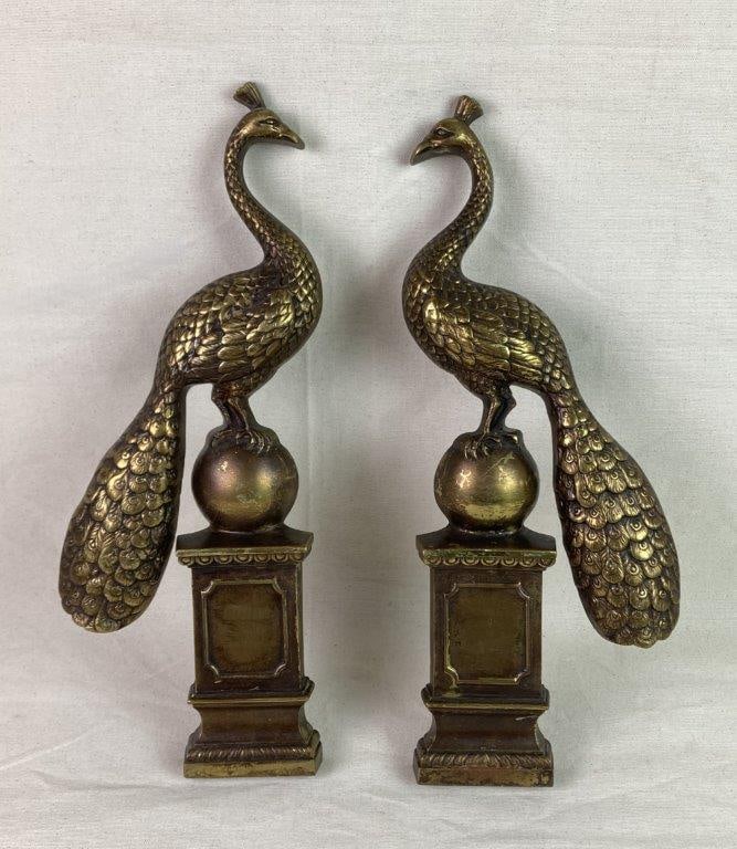 Cast Iron Peacock Door Handles: A pair of cast iron door handles featuring an intricate peacock perched on a spherical form, finished in a brass-toned surface. Displays a worn, aged patina throughout. One handle measures