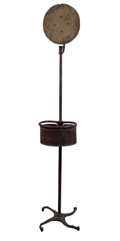 19th Century Country Store Display: A 19th century country store display featuring a swivel top with an oval-shaped tray encircled by a cylindrical rim. The ornate base is decorated with embossed floral motifs, and the surface retains a