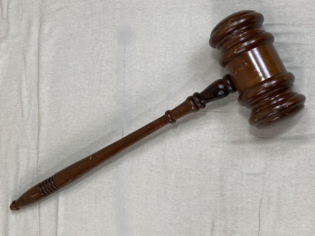 Large Wood Gavel: A large wood gavel featuring a turned handle and substantial cylindrical head, finished in warm tones that highlight the natural grain. The surface retains a worn patina, lending character and