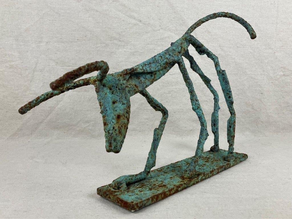 Folk Art Bronze Bull Sculpture: A folk art bronze sculpture in a bold brutalist style, depicting a bull with strong, abstracted form. Finished with verdigris and an aged patina. Measures approximately 11 3/4â€³ H x