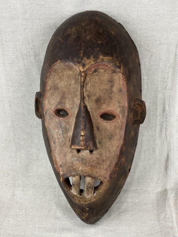 African Lega Lukwakongo Mask: A hand-carved wooden Lukwakongo mask from the Lega people of the Republic of the Congo, depicting a characteristic stylized face. Such masks are an important part of the Bwami Society, serving as