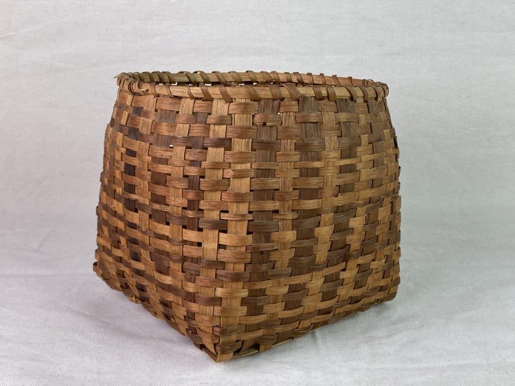 Native American Storage Basket: A nicely woven split oak storage basket with pleasing two-tone coloration and a wrapped rim. Measures approximately 8â€³ H x 9â€³ W x 9â€³ D. In good