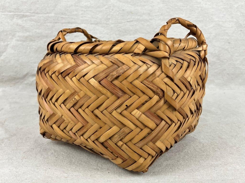 Native American Gathering Basket: A finely woven rivercane and split oak gathering basket with a wrapped rim, featuring pleasing two-tone coloration and rivercane handles. Exhibits a softly worn patina from use. Measures