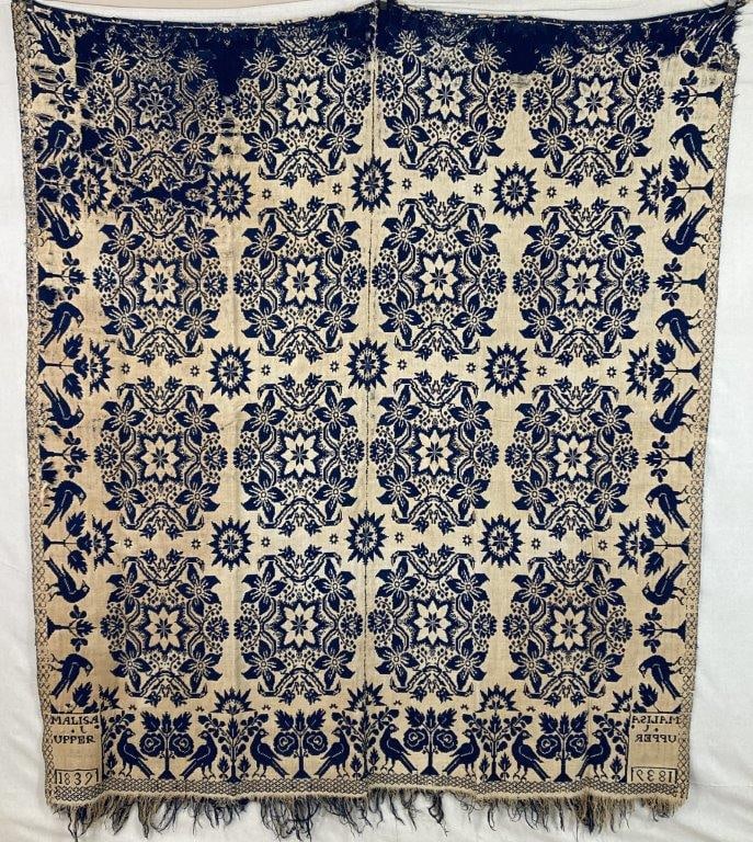 Melisa C. Upper American Woven Coverlet, 1839: An American signed woven coverlet featuring rich blue tones on a cream ground, arranged in distinctive floral patterning with birds decorating the border. The intricate woven design reflects