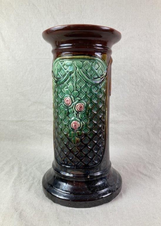 Floral Pottery Pedestal: A pottery pedestal featuring a distinctive relief of roses set against a basketweave pattern, finished with a high-gloss glaze. Designed with a round base and matching circular top, exhibiting an