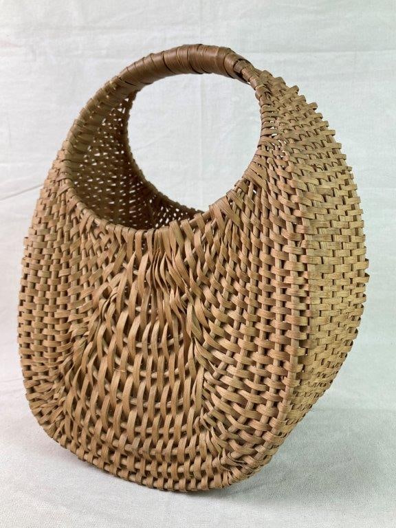 Woven Moon Bag: A nicely woven split oak moon bag with a distinctive half-moon silhouette and integrated handle. Exhibits pleasing surface texture and traditional basketry form. Measures approximately 14″ H x