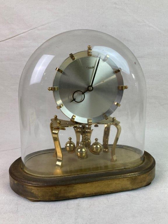 Kundo 400-Day Anniversary Clock: A 400-day anniversary clock by Kundo, featuring a brass-toned base with a sleek metal dial. The movement is a torsion pendulum system with four brass balls, designed to operate for approximately 400