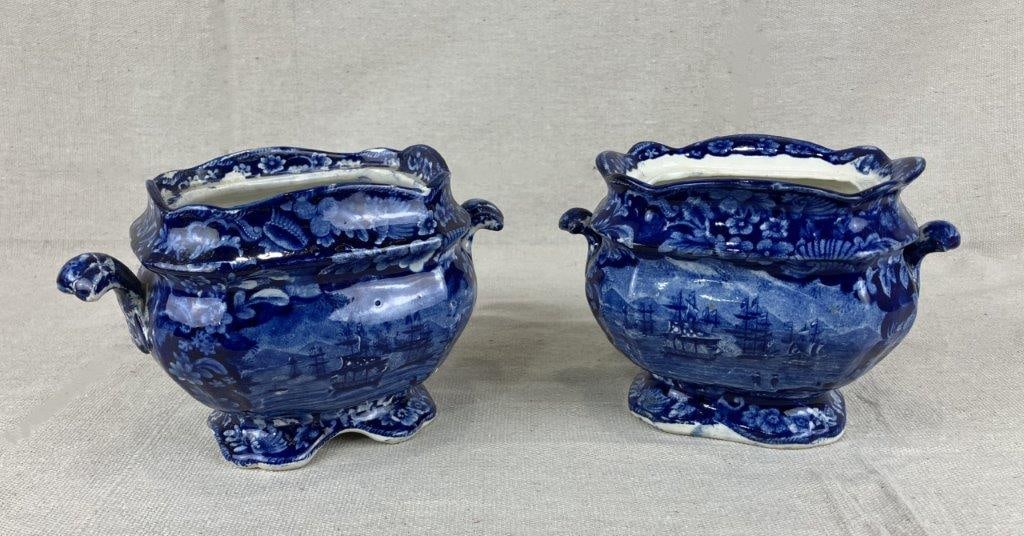 Two Staffordshire Transferware Sugar Bowls: A pair of Staffordshire transferware sugar bowls decorated in characteristic deep blue, each featuring a central ship motif surrounded by floral ornamentation. One bowl measures approximately