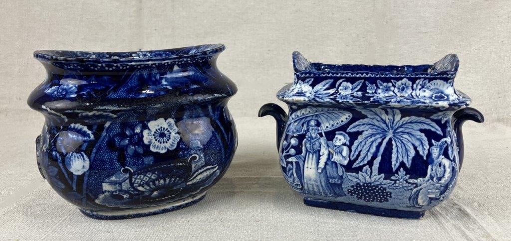 Two Staffordshire Transferware Sugar Bowls: A pair of Staffordshire transferware sugar bowls, one decorated with a scene of interacting figures in an Eastern landscape framed by floral details, the other featuring a flower basket motif. One