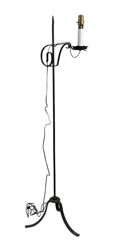 Wrought Iron Floor Lamp: A wrought iron floor lamp featuring a straight shaft supported by a tripod base. Measures approximately 57″ H x 13″ W x 16″ D. In good condition with light rust and wear to the finis