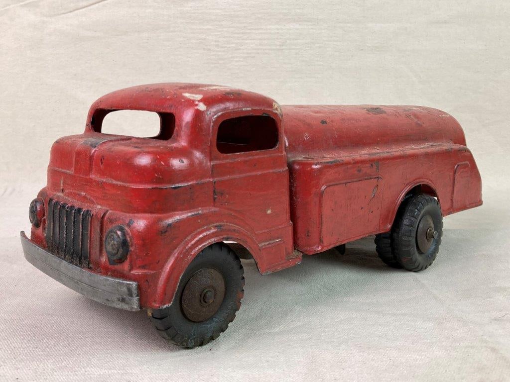 Vintage Structo Steel Toy Truck: A pressed steel toy truck finished in red paint, manufactured by Structo. Fitted with rubber wheels marked â€œStructo Toysâ€ and featuring a wind-up mechanism. The und
