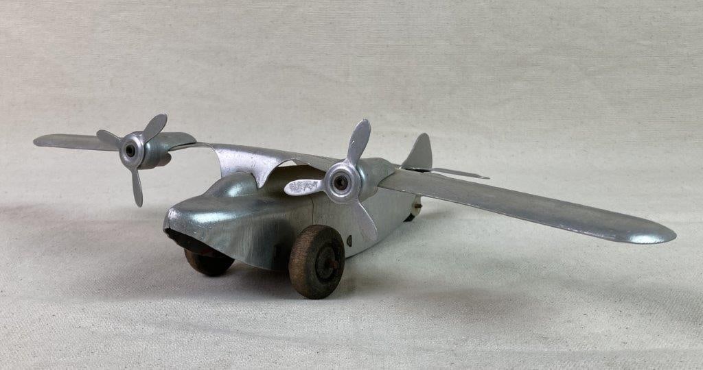 Vintage Automatic Toy Co. Silver Eagle Plane Toy: A pressed steel toy airplane by Automatic Toy Co., featuring propeller engines and â€œSilver Eagleâ€ lettering across the wings. The wind-up mechanism reflects early m