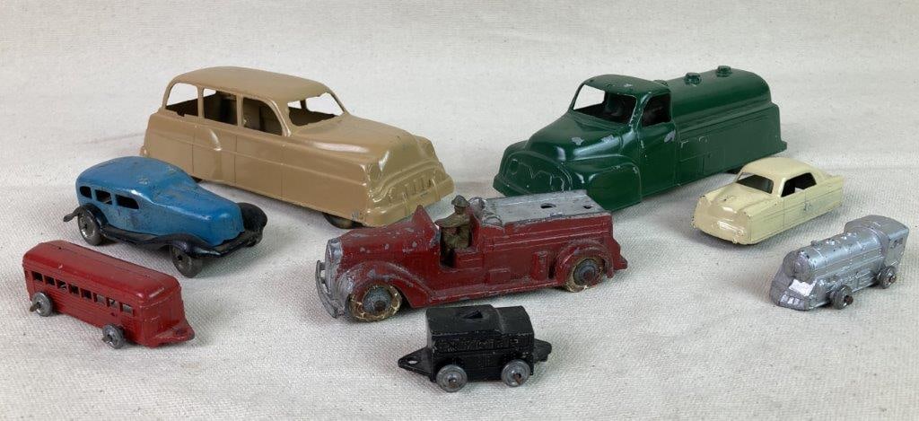 Assortment of Vintage Tin Toy Vehicles: An assorted group of vintage tin toy vehicles, including two examples by Excel Productsâ€”a tan-colored car and a green truck; three tin train cars by Barclay consisting of a silver-t