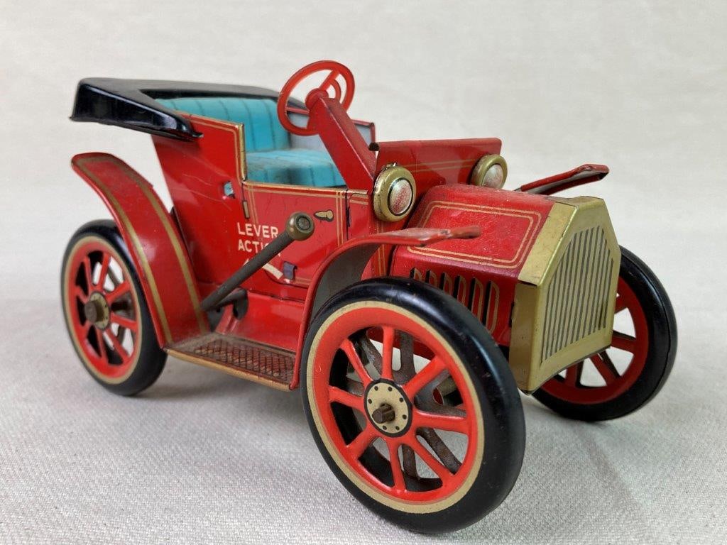 Vintage Tin Litho Car: A red tin lithographed â€œLever Actionâ€ Old Timer model toy car made by Modern Toys of Japan. Features lithographed details and operates via a lever-action mechanism.
