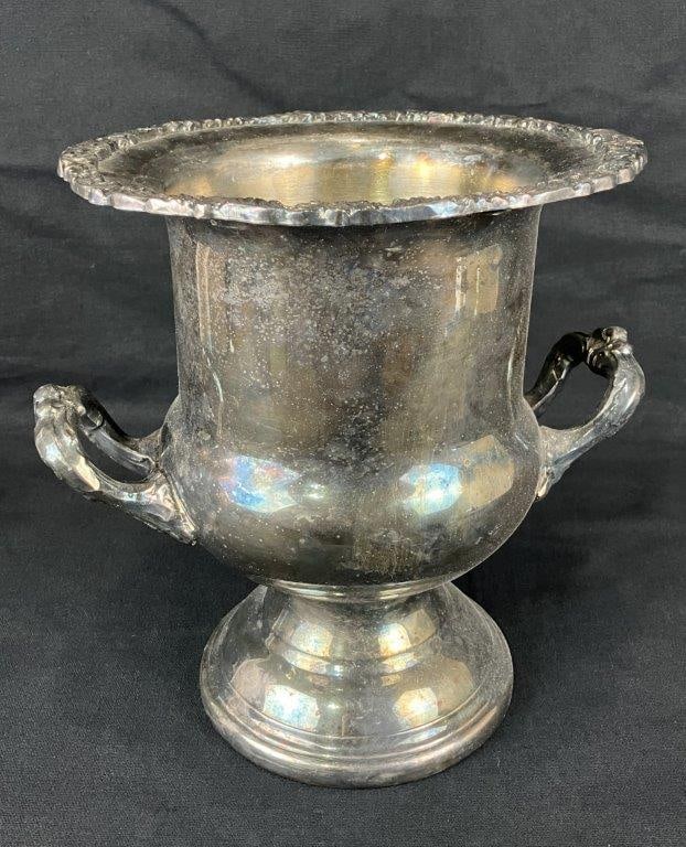 Silverplate Wine Cooler: A silverplate wine cooler by Pilgrim Silver Manufacturing Company, featuring a floral border along the upper lip, scrollwork handles, and a robust, curving form. Measures approximately 10″ H x