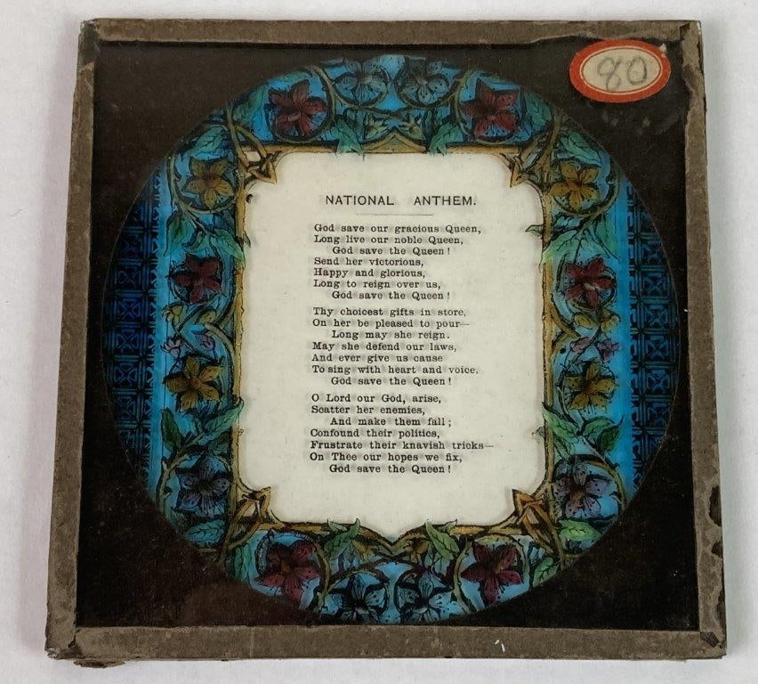 British National Anthem Magic Lantern Slide: A square-format magic lantern slide displaying the words of the British National Anthem, surrounded by an ornate, multi-colored floral border. Produced during the reign of a female monarch. Exhibits