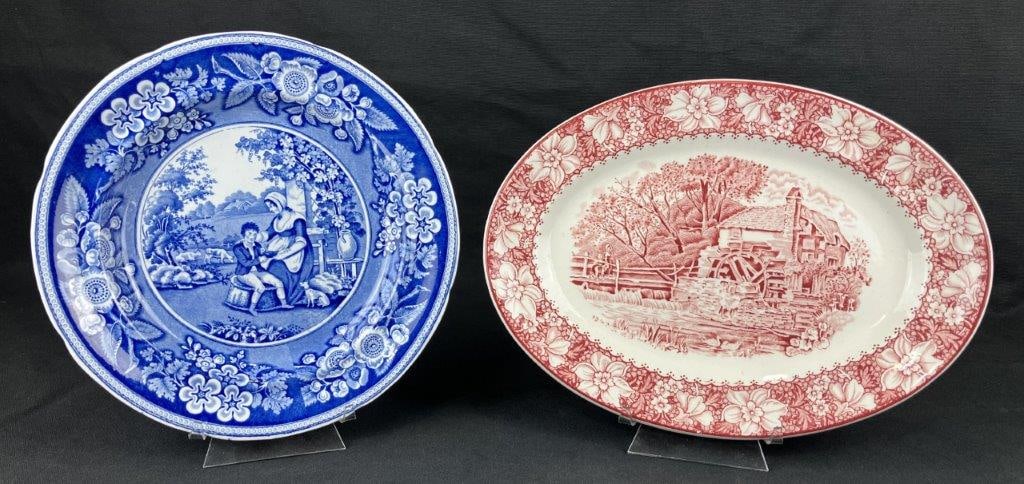 Two English Transferware Plates: A pair of English transferware plates, one decorated in red and the other in blue, each depicting scenic European country landscapes. The blue example is by Woods & Sons in the Colonial pattern. The