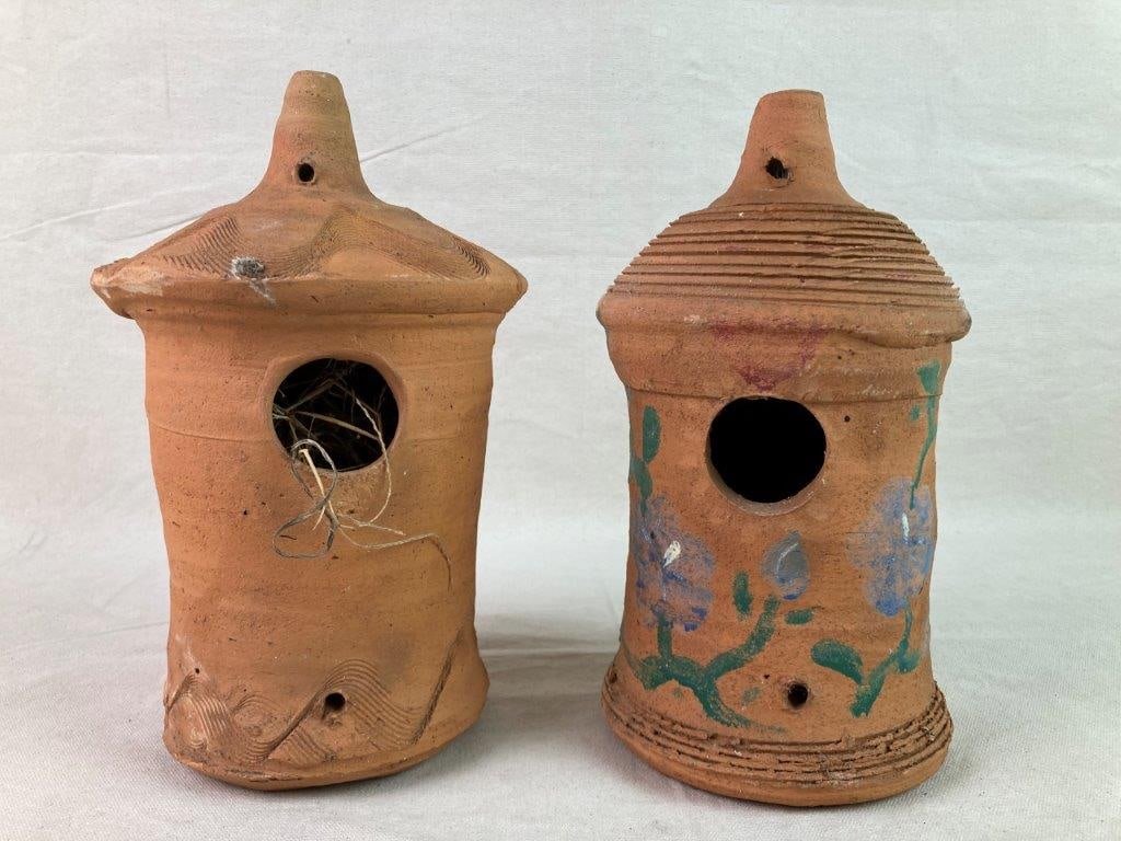 Hewell Pottery Terracotta Birdhouses: Two hand-made terracotta bird houses produced by Hewells Pottery. One example features incised combed lines to the base and roof, accented with a painted blue flower and green leaf motif; the other