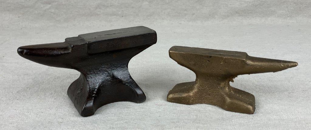 Miniature Cast Iron Anvil Pair: A pair of miniature cast iron anvils with decorative appeal, ideal for use as paperweights. The larger example measures approximately 2 3/4″ H x 5″ W x 1 1/2″ D. In good condition. 