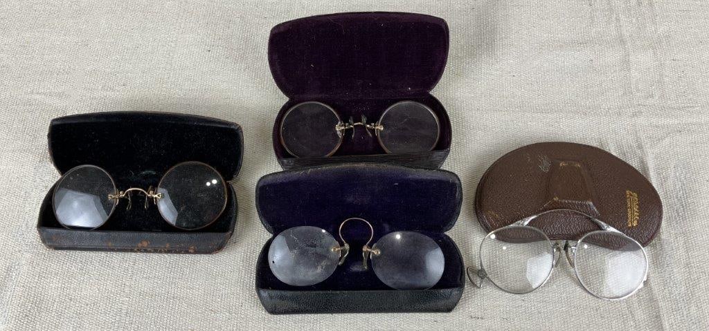 Four Pince-Nez Spectacle Glasses: A group of four pince-nez spectacle glasses dating from the late 19th to early 20th century, accompanied by coordinating leather cases, including one marked New York. One case measures approximately