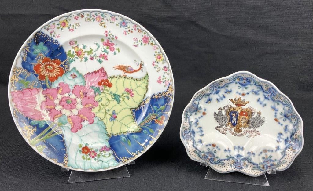 Two Hand-Painted Porcelain Plates: A pair of hand-painted porcelain plates, including one example with an armorial design in blue-and-white glazing, centered by a painted crest and finished with a scalloped edge, and another by