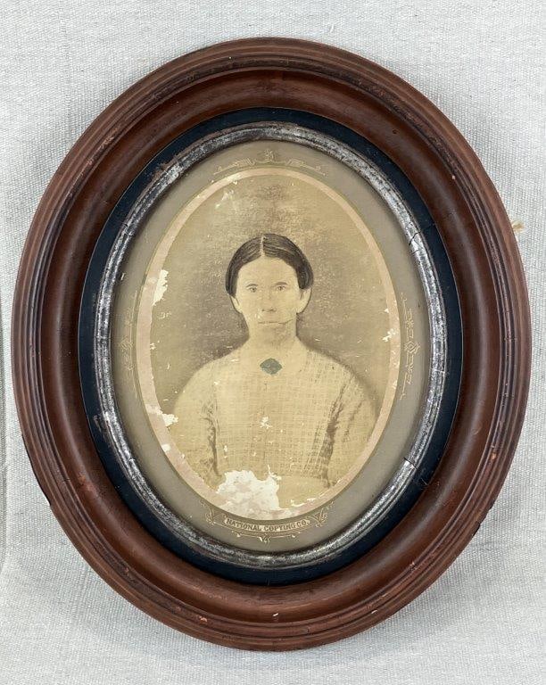 19th Century Hand-Colored Photograph: A 19th century hand-colored photograph enhanced by painting in a grey scale produced by National Copying Co., depicting a working-class woman in traditional attire. Housed in an oval wooden frame