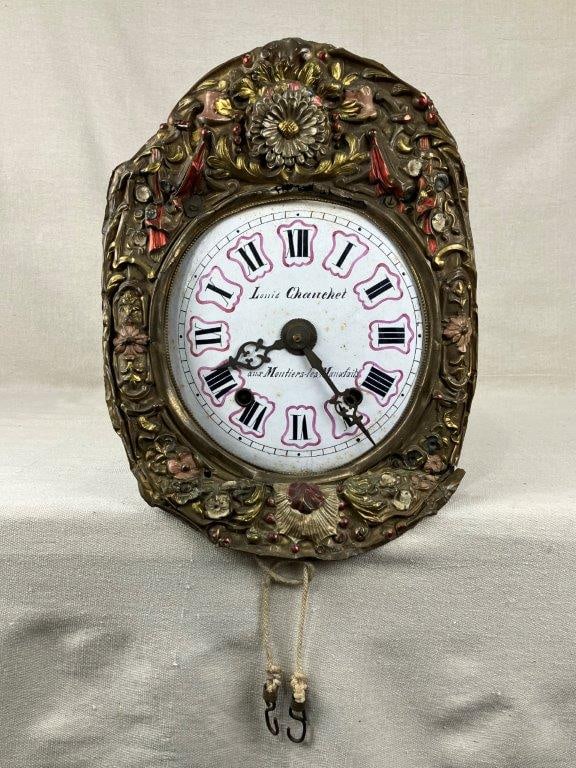 French Brass Repousse Comtoise Clock: A 19th century French brass repoussé Comtoise clock executed in the Rococo Revival style, signed by the maker Louis Chauchet and bearing provenance to Aux Moutiers-les-Mauxfaits. The case display