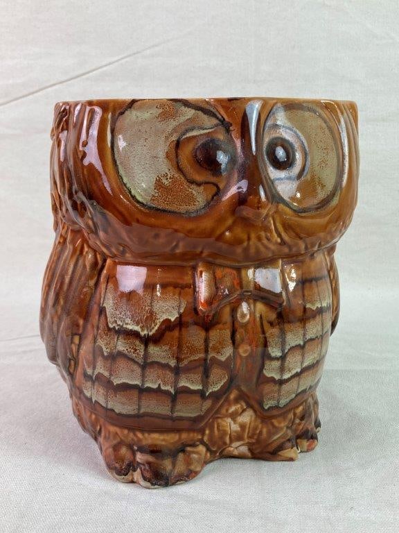Pottery Owl Jar: A whimsical pottery owl jar modeled with a chubby, big-eyed form, wearing a button-up shirt and bowtie. Finished in a glossy brown glaze and retaining a softly worn patina. Measures approximately 8