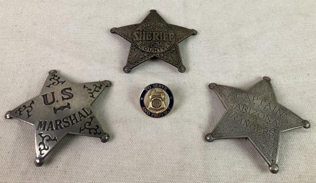 Four Law Enforcement Badges and Pin: A group of vintage law enforcement items, including three silver-tone five-pointed star badges and one pin. The badges include examples marked â€œU.S. Marshalâ€ with