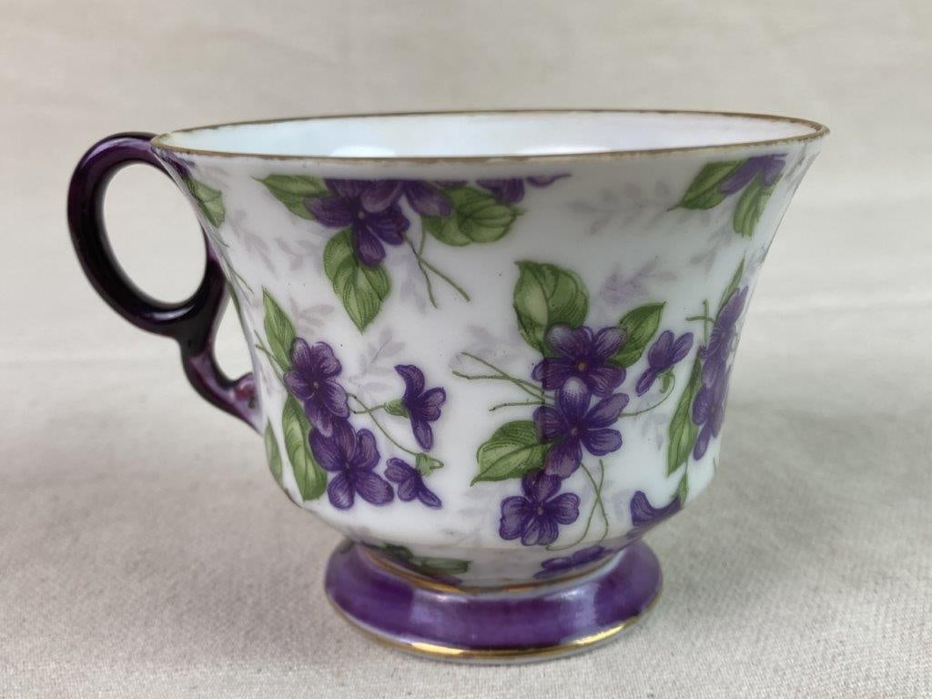 Demitasse Cup: A vintage demitasse cup decorated in a purple-violet chintz pattern with gold gilt trim, featuring a matching purple handle and base. Marked “E-960” on the underside. Measures