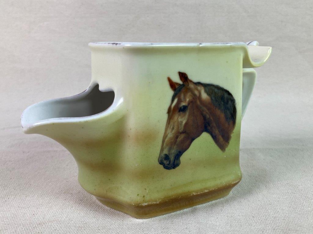 Porcelain Equestrian Shaving Mug: A porcelain shaving mug designed to hold soap, decorated with a painted horse head motif. Exhibits a softly worn patina from age and use. Measures approximately 3 7/8″ H x 3 1/8″ W x 6