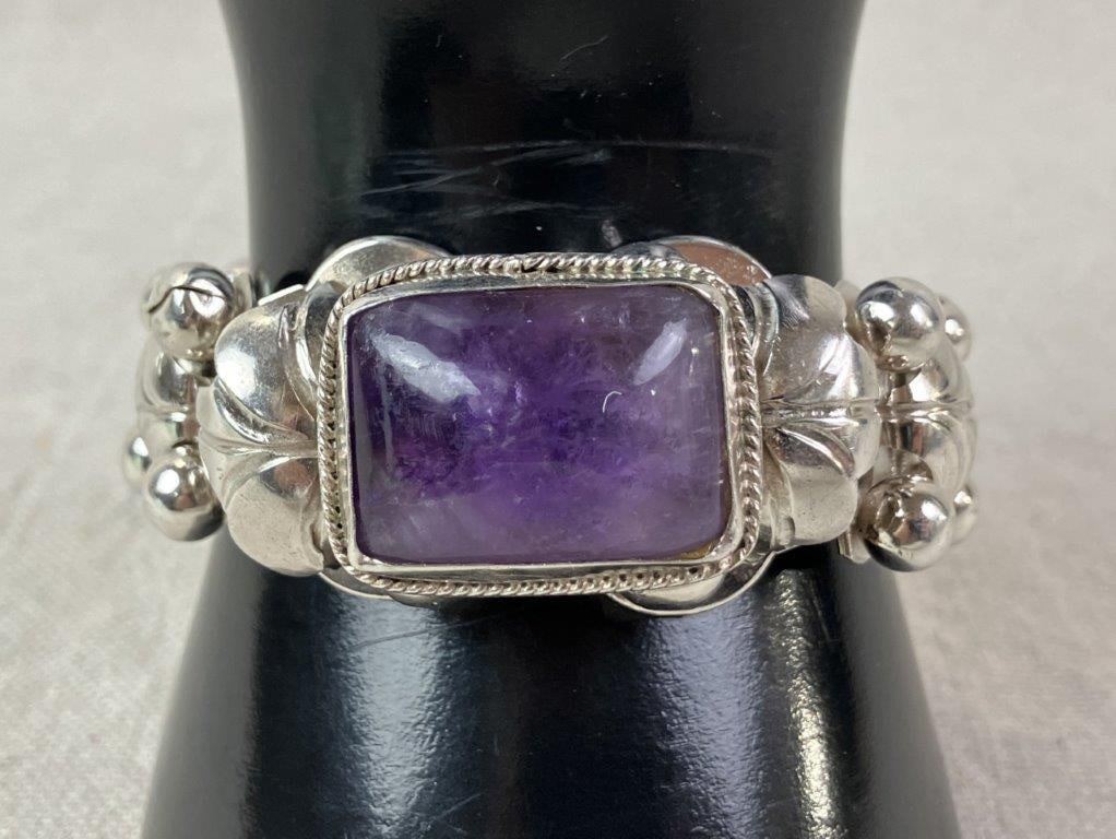 Design Craft Sterling Silver and Amethyst Bracelet: Design Craft sterling silver bracelet crafted in Mexico and marked Sterling to interior, centering a rectangular amethyst cabochon within a robust composition of leaf-form links accented with silver