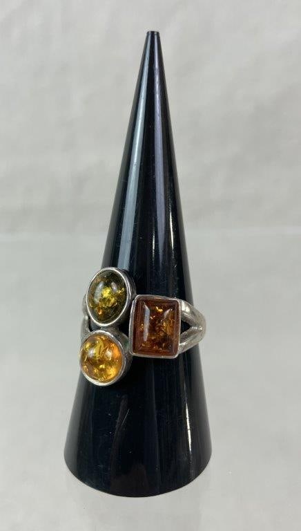 Artisan Sterling Silver and Amber Three-Stone Ring: Artisan sterling silver ring set with three warm amber stones arranged across the top of a gracefully contoured sterling silver band. Ring size approx. 8 1/2. Total weight including stones approx.