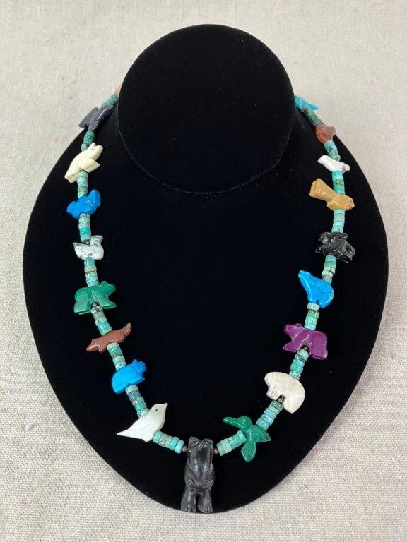 Zuni Fetish Necklace: Single-strand fetish necklace featuring multiple carved animal motifs crafted from semi-precious stones including blue goldstone, jet, and turquoise, depicting bears, birds, and a rabbit. Accented