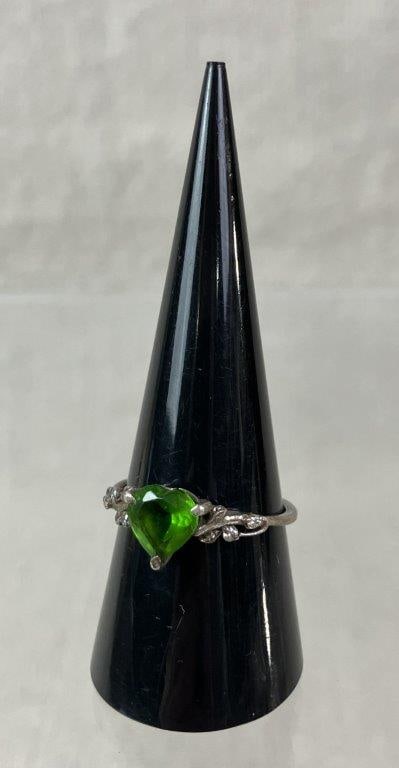 Sterling Silver and Peridot Heart Ring: Sterling silver ring centering a heart-shaped faceted peridot in a raised gallery setting, the band adorned with vine motifs and clear faceted accent stones, joined with a simple adjoining band. Ring