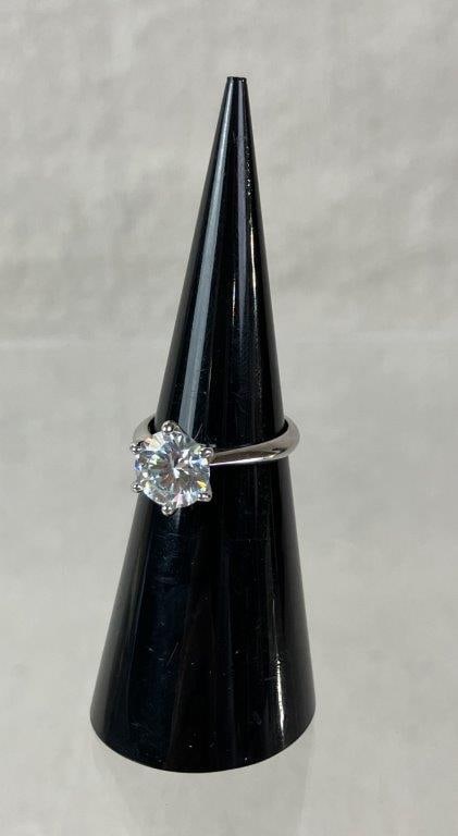 Vosali Moissanite Sterling Silver Ring: Vosali brand sterling silver ring set with a round-cut moissanite displaying a brilliant faceted effect, secured within distinctive prong mountings. Interior marked “Vosali” and 925. Ring