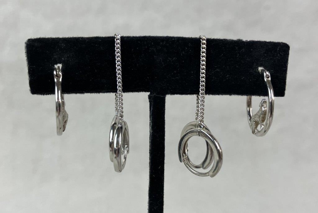 Pair of Sterling Silver Hoop Earrings: Elegant pair of sterling silver hoop earrings in delicate forms, including one huggie-style pair featuring a howling wolf motif to the interior. Marked 925. One hoop measures approx. 3/8" diameter.