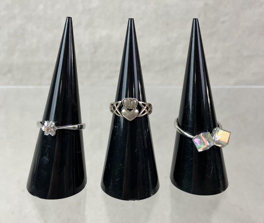 Three Sterling Silver Rings: Group of three sterling silver rings in delicate forms, including one set with faceted stones (ring size approx. 7 1/2), one classic Claddagh ring (size approx. 4), and one floral design ring (size ap