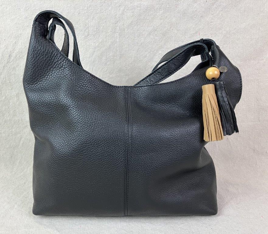 The Sak Huntley Leather Hobo Bag: Black leather hobo bag crafted in genuine black pebbled leather made by The Sak, designed with two leather shoulder straps and a magnetic top closure. Accented with a two-toned tassel featuring a