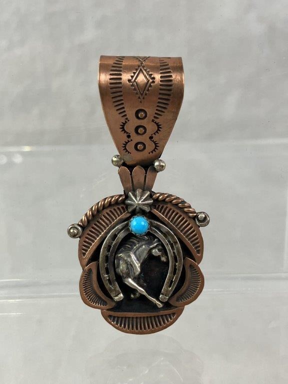Native American Copper over Sterling Silver Horse Pendant: Native American pendant featuring a central turquoise cabochon set above a silver horse and horseshoe motif, framed by copper over sterling silver in a bold, dimensional design. Reverse stamped by