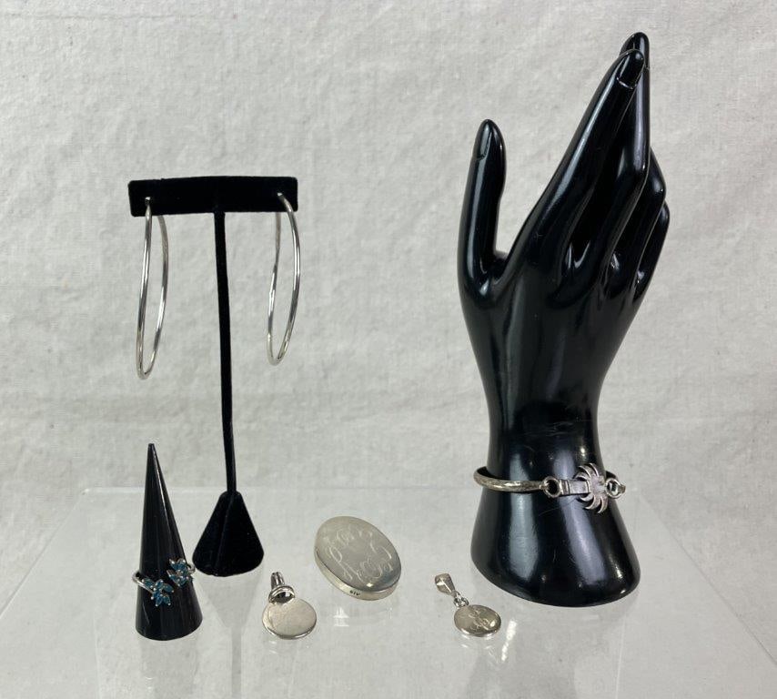 Sterling Silver Jewelry Assortment: Sterling silver jewelry assortment including a variety of silver-marked pieces, comprised of one bracelet accented with a palm tree charm, one ring, and several monogrammed examples. Ring size