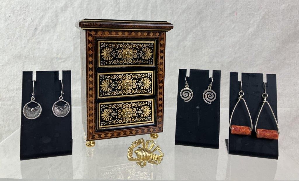 Toledo Damascene Spanish Jewelry Box: Small three-drawer Toledo Damascene jewelry box crafted of fine-grain wood, decorated to the front and top in gold-tone Damascene technique, and raised on gold-tone feet with matching knobs. Includes