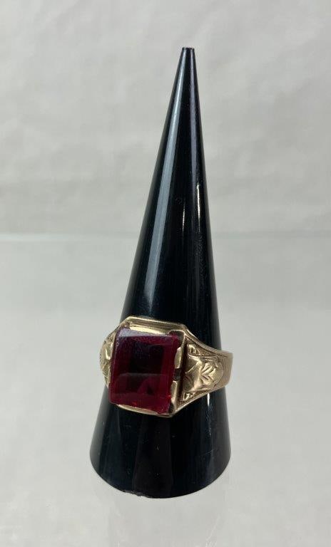 Men's 10 Kt Gold Rhodolite Garnet Ring: Vintage men's 10 kt gold ring set with a square-cut rhodolite garnet in a raised gold mount, framed by leafy motif detailing and a robust tapered band. Interior marked 10kt with maker's logo. Ring