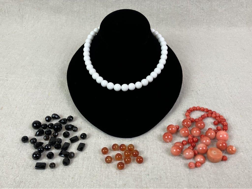 Lot of Polished Beads: Collection of polished beads including red coral examples in both small and large sizes, black onyx beads in polished and faceted forms, polished spherical carnelian beads, and a strand of white