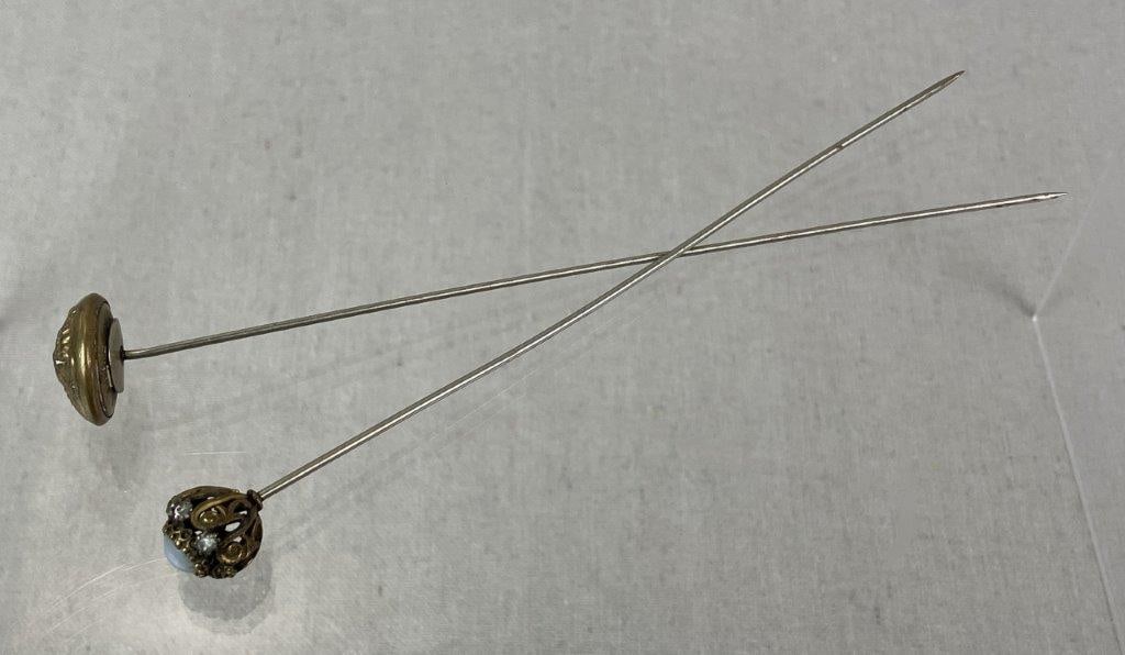 Two Late 19th–Early 20th Century Goldtone Hat Pins: Grouping of late 19th to early 20th century goldtone hat pins, including one fashioned from a military jacket button with central eagle and crest motif, and another featuring a faux moonstone center