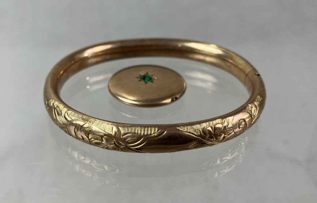 Goldtone Locket and Bangle Bracelet: Gold tone jewelry grouping including a locket containing period photographs and engraved with an outer monogram to one side, accented by a baguette-cut green faceted stone. Accompanied by a