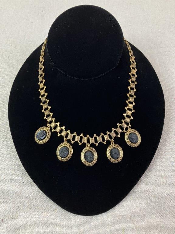Black Cameo Necklace: Antique black cameo necklace reminiscent of 19th-century mourning jewelry, featuring a brass chain set with five separate cameos depicting a woman in profile, rendered in a material imitating