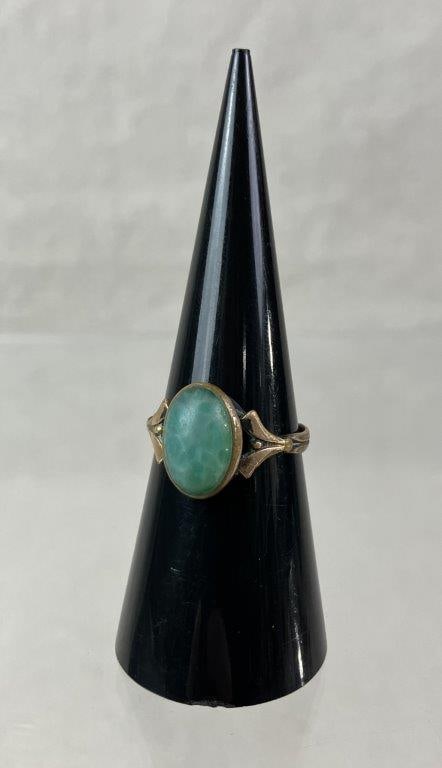 Artisan Ring: Artisan likely gold filled ring featuring a central jade-like stone set within a decorative mount, the shoulders transitioning into a simple band with angular geometric detailing reflective of handcra