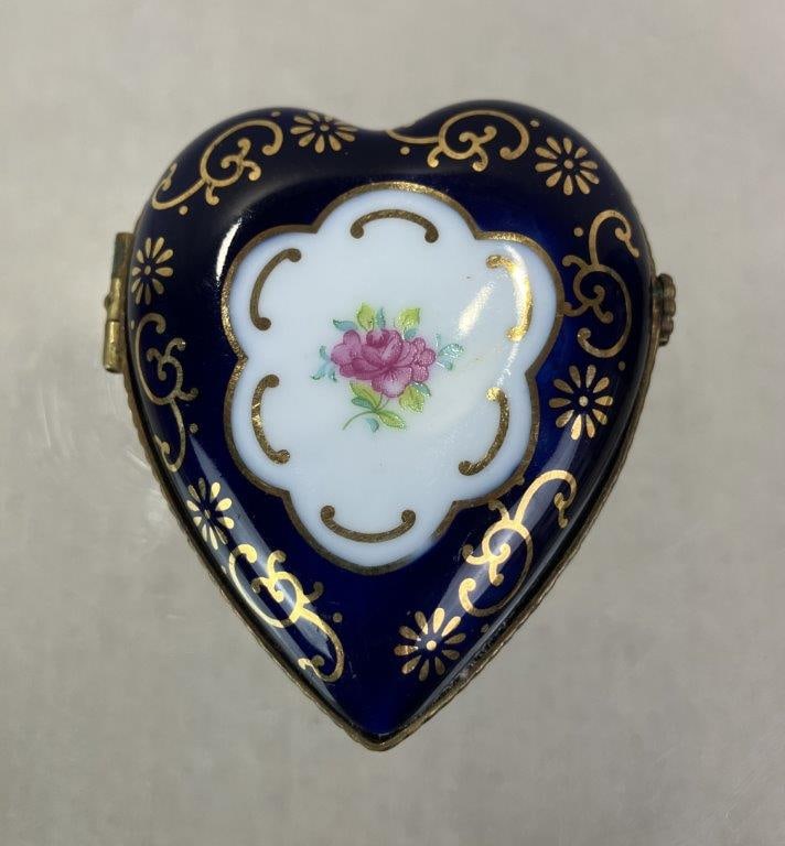 Heart Hand Painted Porcelain Trinket Box: Heart-shaped hand-painted porcelain trinket box in the French taste, featuring romantic decoration and the interior phrase “Je T’aime.” Finished with brass border and hinged