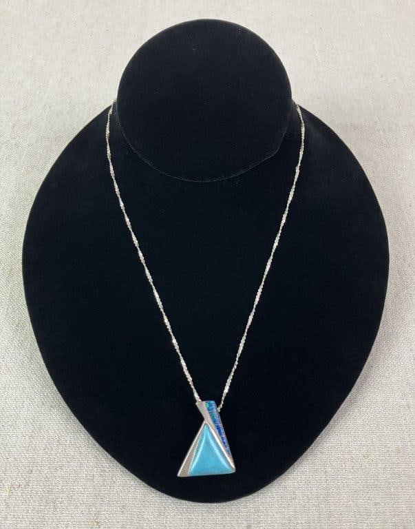 Sterling Silver, Turquoise, and Blue Opal Triangle Necklace: Modernist artisan-crafted necklace featuring a central turquoise stone framed within a triangular sterling silver mount inlaid with blue opal. Reverse stamped “Sterling” and “R